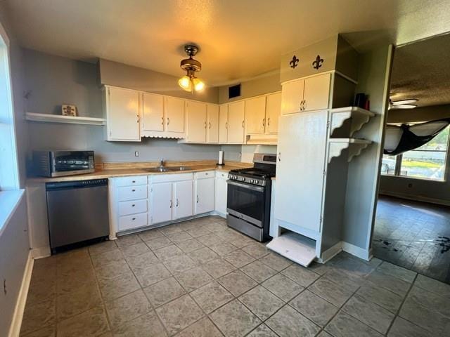 kitchen with white cabinets, stainless steel appliances, ceiling fan, and sink