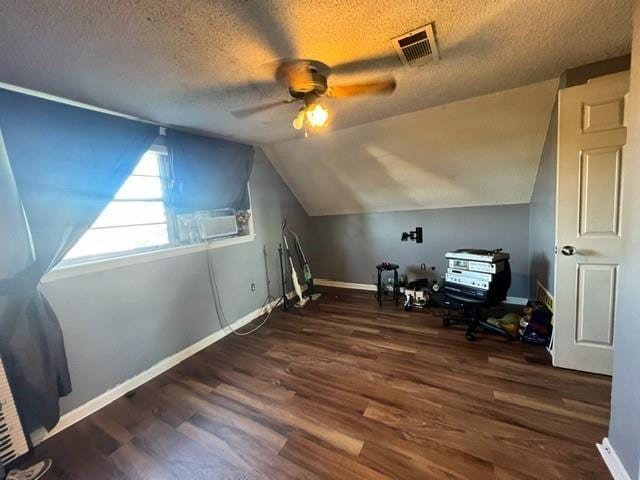 bonus room featuring vaulted ceiling, ceiling fan, dark wood-type flooring, and a textured ceiling