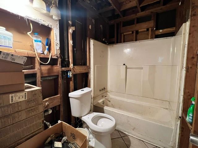 bathroom with tile patterned floors, toilet, and washtub / shower combination