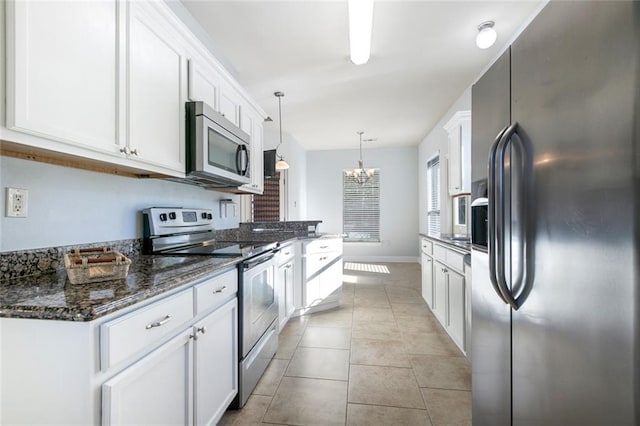 kitchen with white cabinets, pendant lighting, and stainless steel appliances