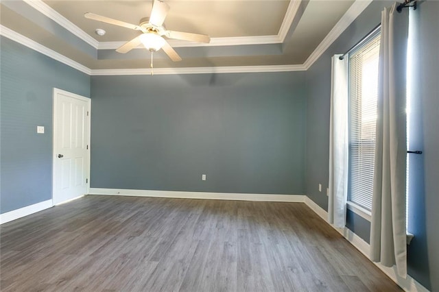 unfurnished room featuring wood-type flooring, a tray ceiling, ceiling fan, and ornamental molding