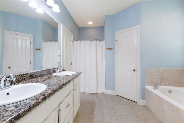 bathroom with tile patterned flooring, vanity, and tiled bath