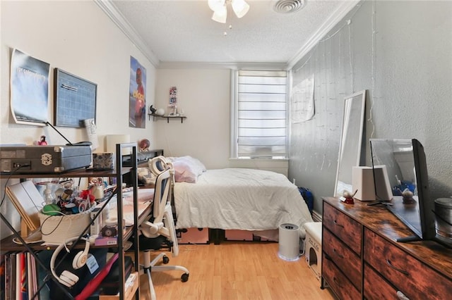 bedroom featuring crown molding, ceiling fan, a textured ceiling, and light wood-type flooring