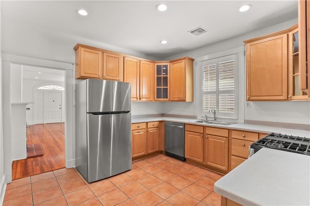 kitchen with light brown cabinetry, sink, light hardwood / wood-style flooring, and appliances with stainless steel finishes