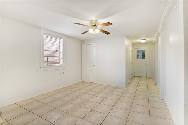 tiled spare room featuring ceiling fan