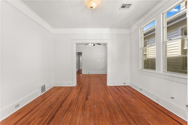 spare room with crown molding and wood-type flooring