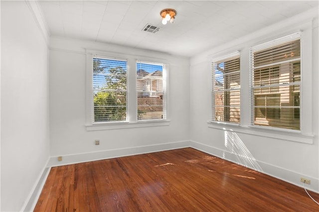 empty room featuring hardwood / wood-style floors and crown molding