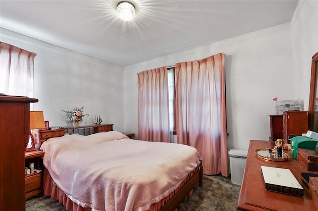 bedroom featuring crown molding and dark carpet