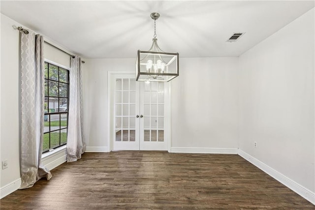 unfurnished dining area with french doors, a chandelier, and dark hardwood / wood-style floors