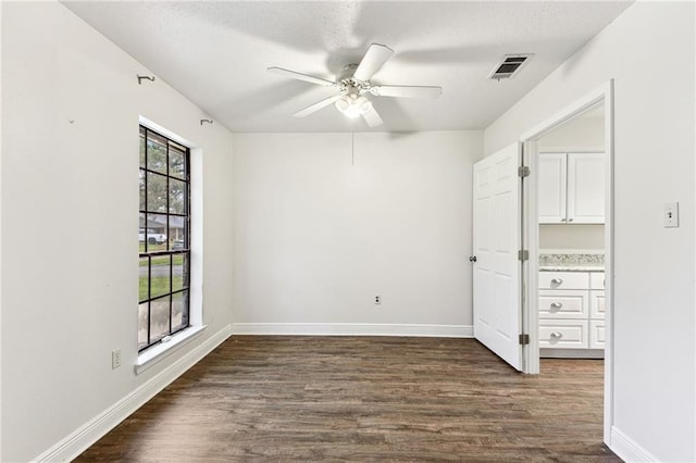 spare room featuring a textured ceiling, ceiling fan, and dark hardwood / wood-style floors