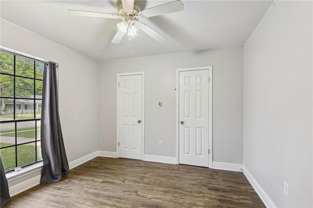 unfurnished room with dark hardwood / wood-style flooring, ceiling fan, and plenty of natural light