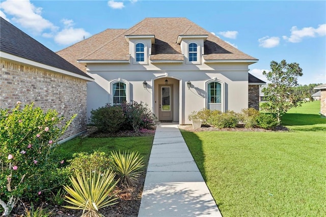 french country style house featuring a front lawn