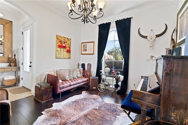 living area featuring dark hardwood / wood-style floors, crown molding, and a chandelier