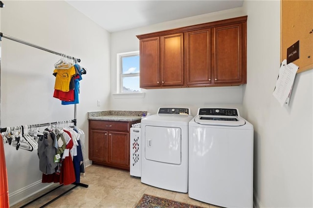 clothes washing area featuring cabinets and washing machine and dryer