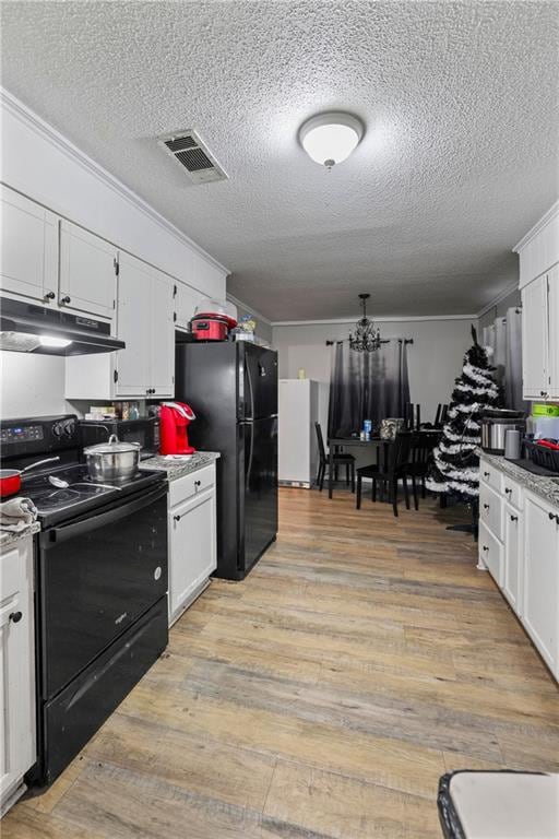 409 Oaklane Dr, Hammond, LA 70403 - kitchen with a textured ceiling, crown molding, black appliances, light hardwood / wood-style flooring, and white cabinets