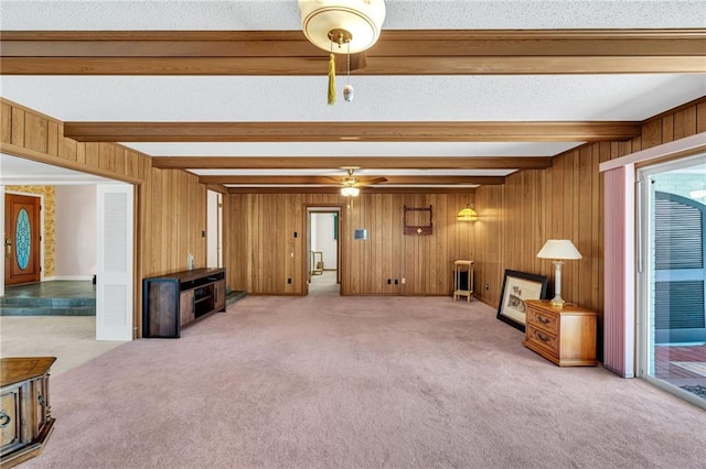 carpeted living room with wooden walls, beamed ceiling, a textured ceiling, and ceiling fan