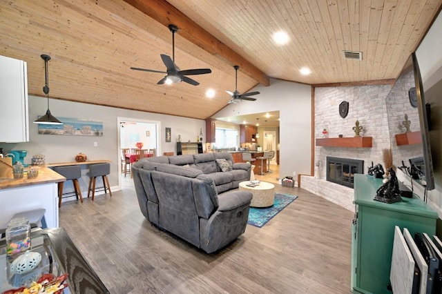 living room featuring vaulted ceiling with beams, a fireplace, wood ceiling, and hardwood / wood-style flooring