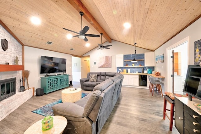 living room featuring vaulted ceiling with beams, wooden ceiling, light hardwood / wood-style floors, and a brick fireplace