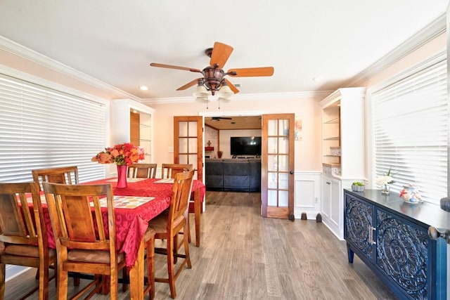 dining space featuring french doors, light wood-type flooring, ceiling fan, and ornamental molding