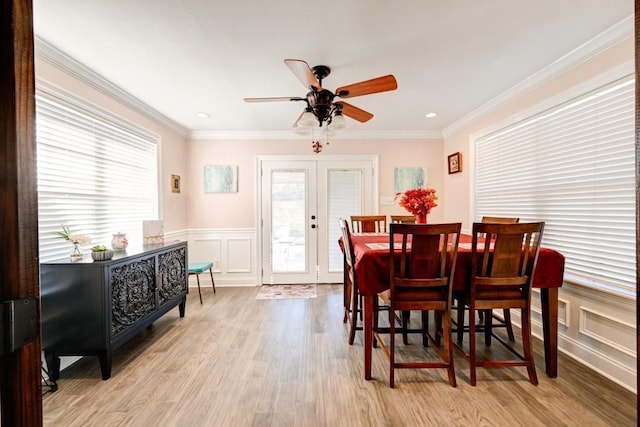 dining room with french doors, light hardwood / wood-style floors, ceiling fan, and ornamental molding