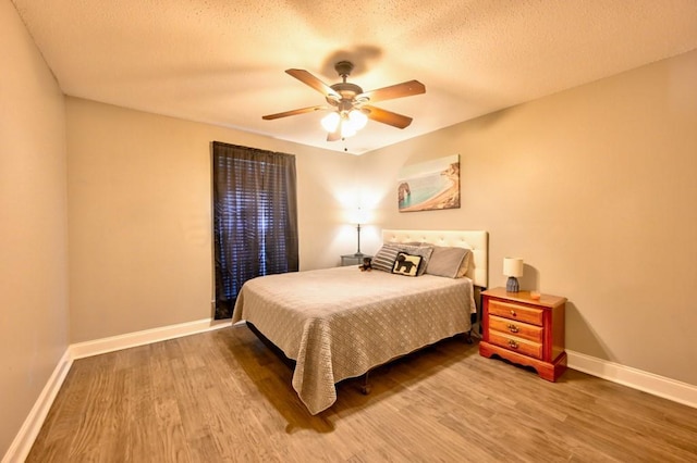 bedroom featuring hardwood / wood-style flooring, ceiling fan, and a textured ceiling