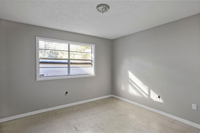 unfurnished room featuring a textured ceiling