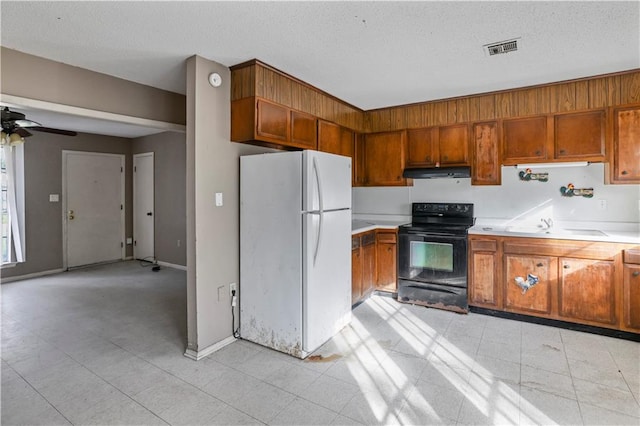 kitchen featuring white refrigerator, sink, electric range, ceiling fan, and a textured ceiling