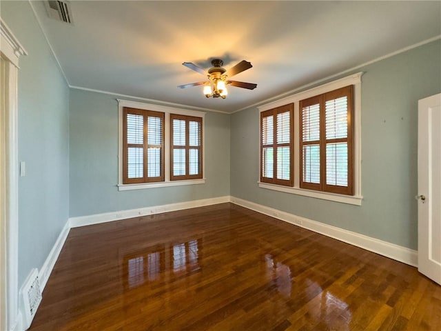 spare room featuring ceiling fan, dark hardwood / wood-style flooring, crown molding, and a wealth of natural light