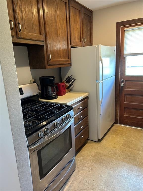 kitchen featuring stainless steel gas range oven and white refrigerator