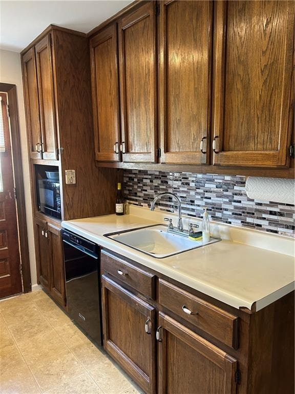 kitchen featuring backsplash, dishwasher, light tile patterned flooring, and sink