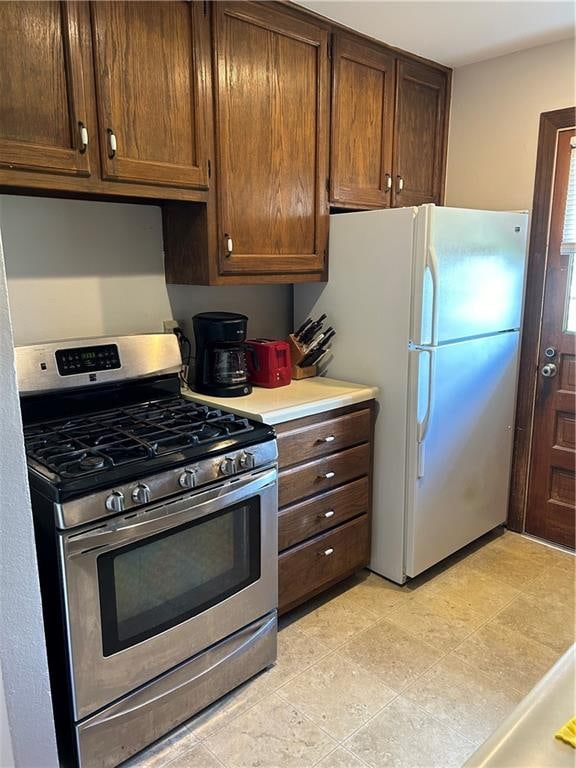 kitchen featuring stainless steel range with gas cooktop and white fridge