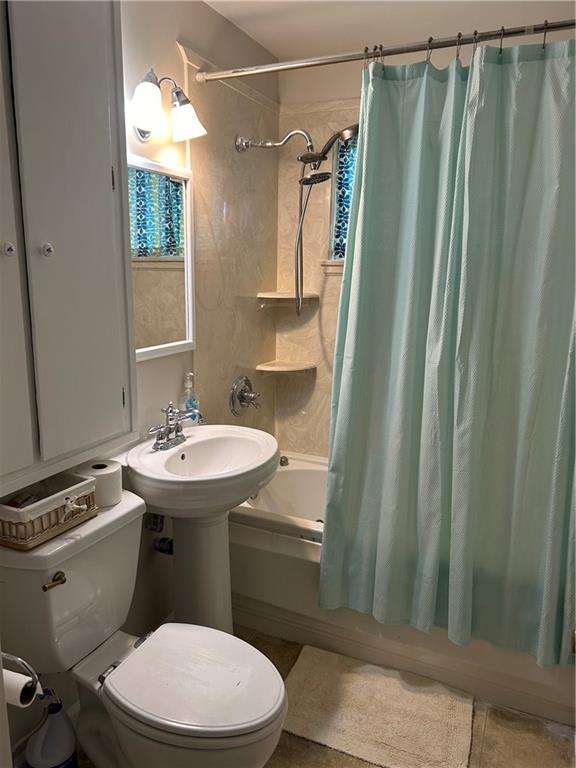 bathroom featuring tile patterned floors, shower / bath combo, and toilet