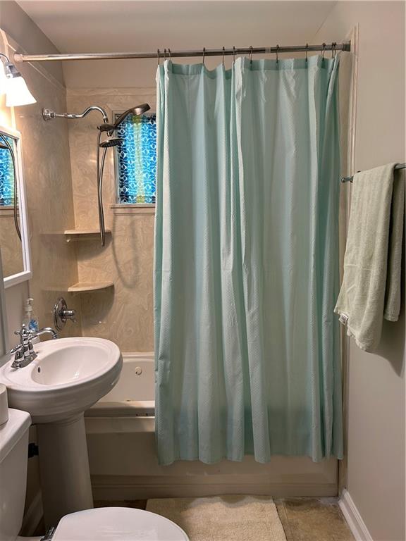 bathroom featuring tile patterned floors, toilet, and shower / bathtub combination with curtain