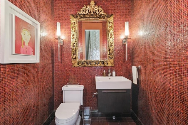 bathroom with tile patterned flooring, vanity, tile walls, and toilet