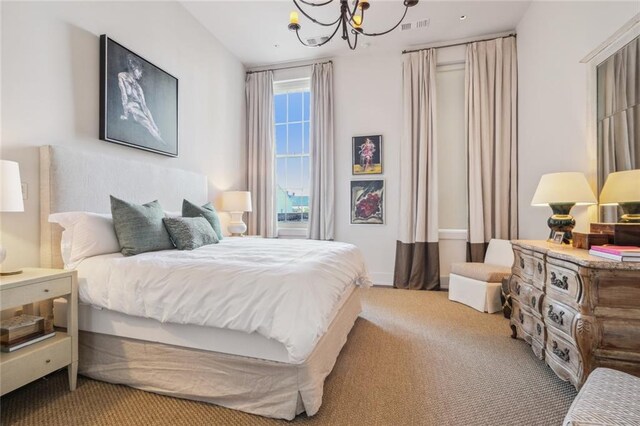 bedroom featuring light carpet and a chandelier