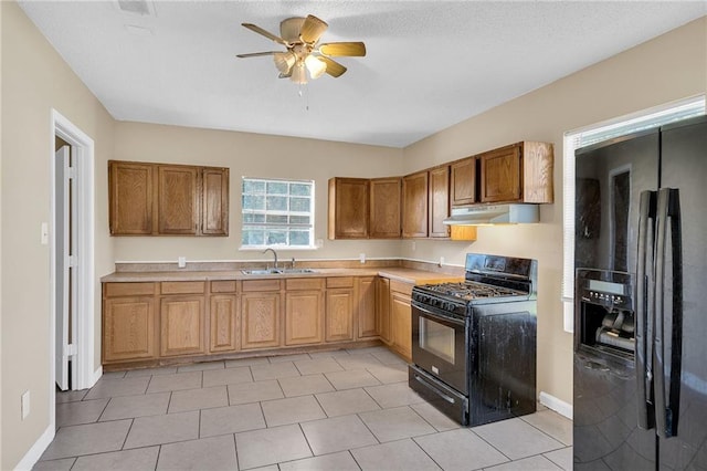 kitchen featuring ceiling fan, sink, light tile patterned floors, and black appliances