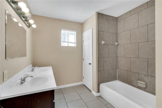 bathroom with tile patterned flooring, vanity, tiled shower / bath combo, and a textured ceiling