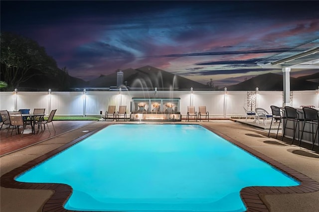 pool at dusk with a patio