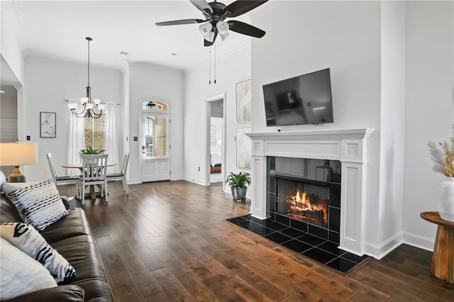 living room featuring a fireplace, ceiling fan with notable chandelier, and dark hardwood / wood-style floors