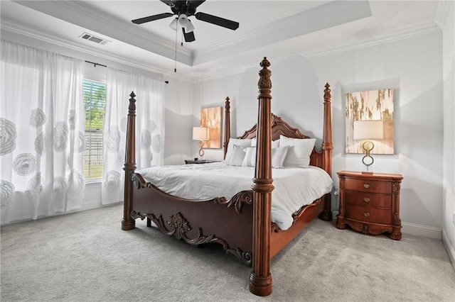 carpeted bedroom featuring a raised ceiling, ceiling fan, and ornamental molding