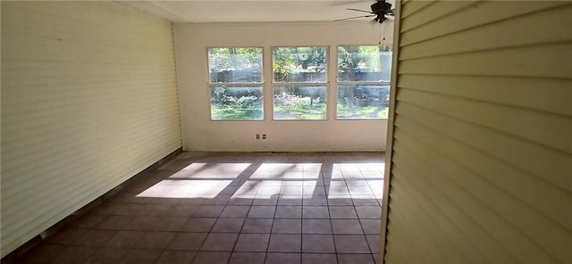 tiled empty room featuring ceiling fan