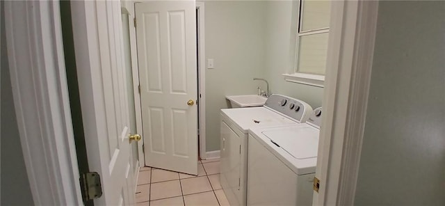 clothes washing area with independent washer and dryer, light tile patterned floors, and sink