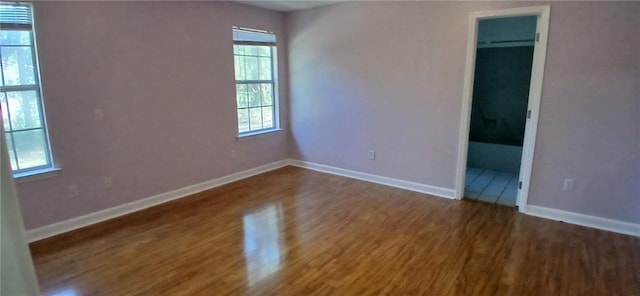 unfurnished room with dark hardwood / wood-style flooring