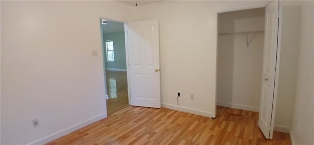 unfurnished bedroom featuring light hardwood / wood-style flooring and a closet