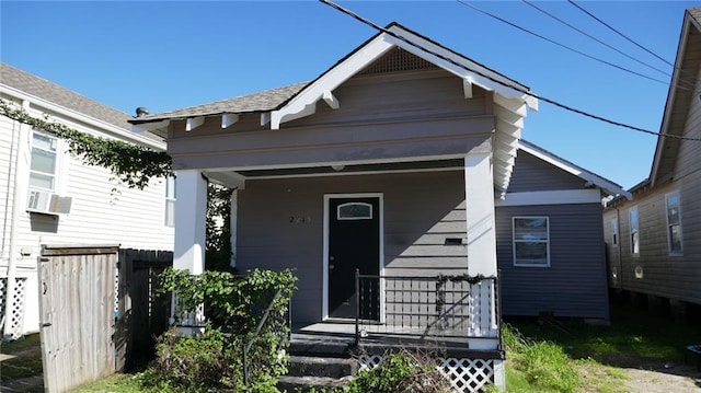 bungalow-style home with a porch and cooling unit