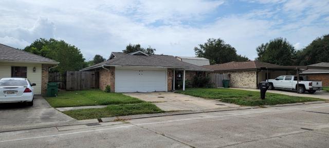 ranch-style house featuring a garage and a front lawn