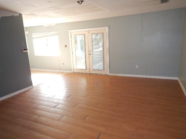 unfurnished room featuring french doors and wood-type flooring