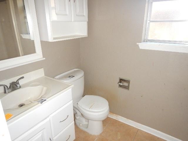 bathroom featuring tile patterned flooring, vanity, and toilet