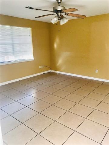 tiled empty room with ceiling fan