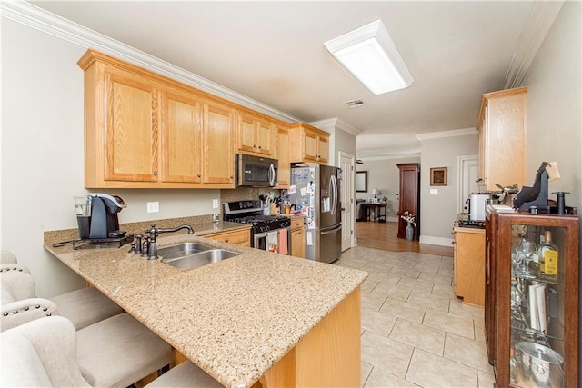 kitchen featuring sink, kitchen peninsula, crown molding, a kitchen bar, and appliances with stainless steel finishes